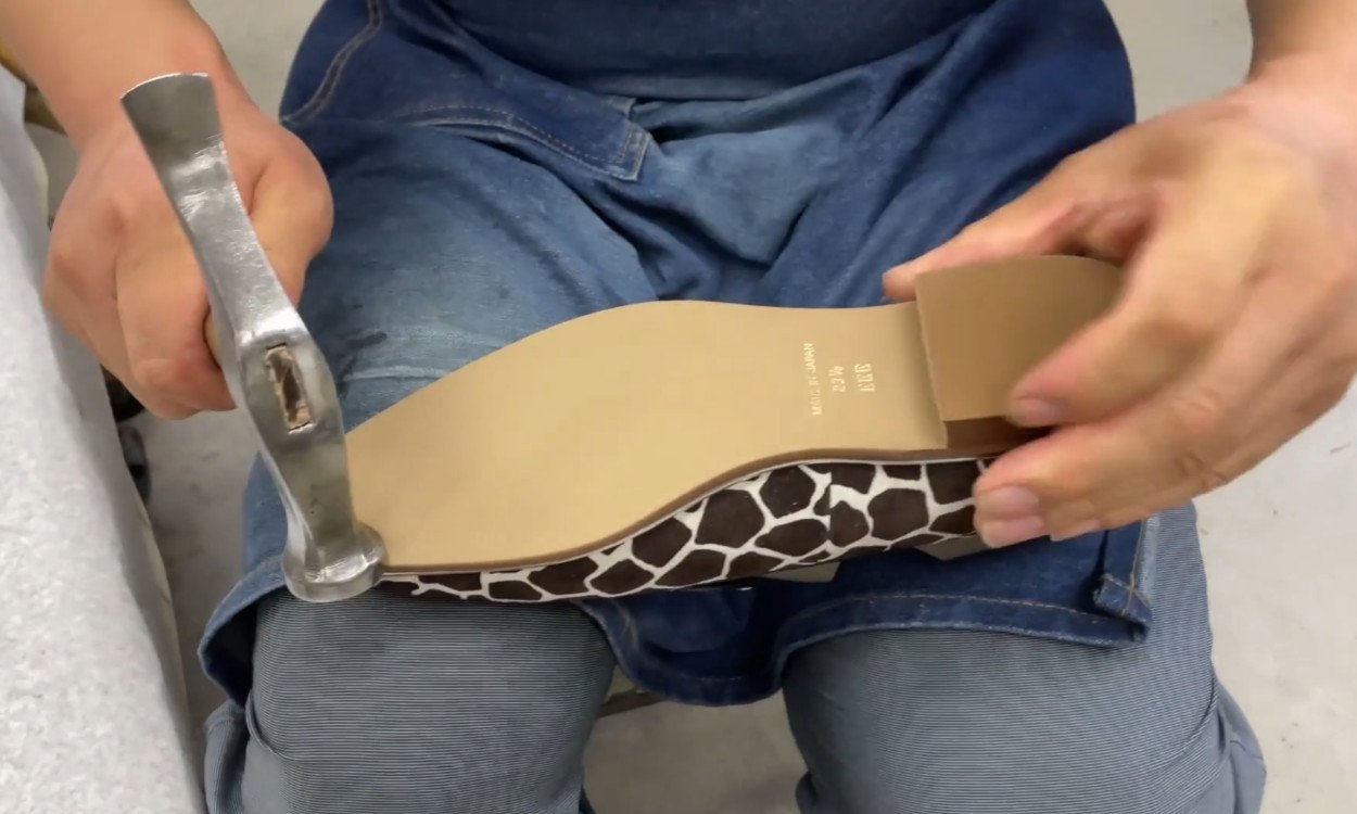 靴職人が手作業で革靴を製造している写真